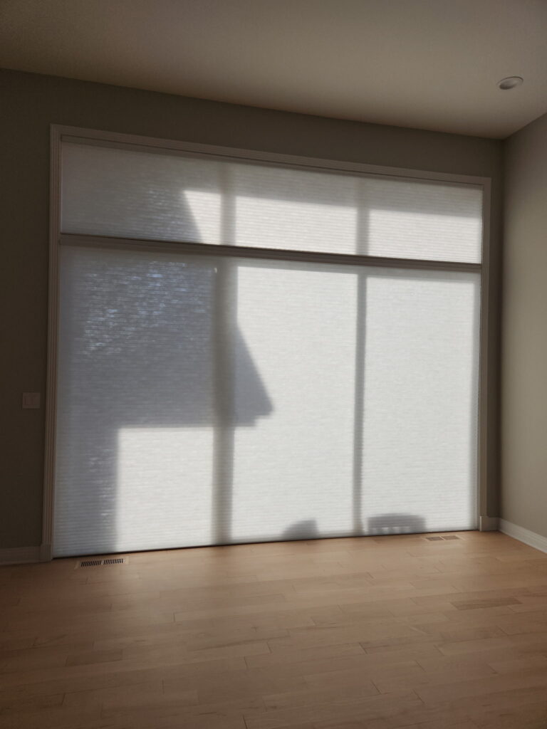 142 inch Hunter Douglas Applause Honeycombs PowerView blinds hanging in an empty room