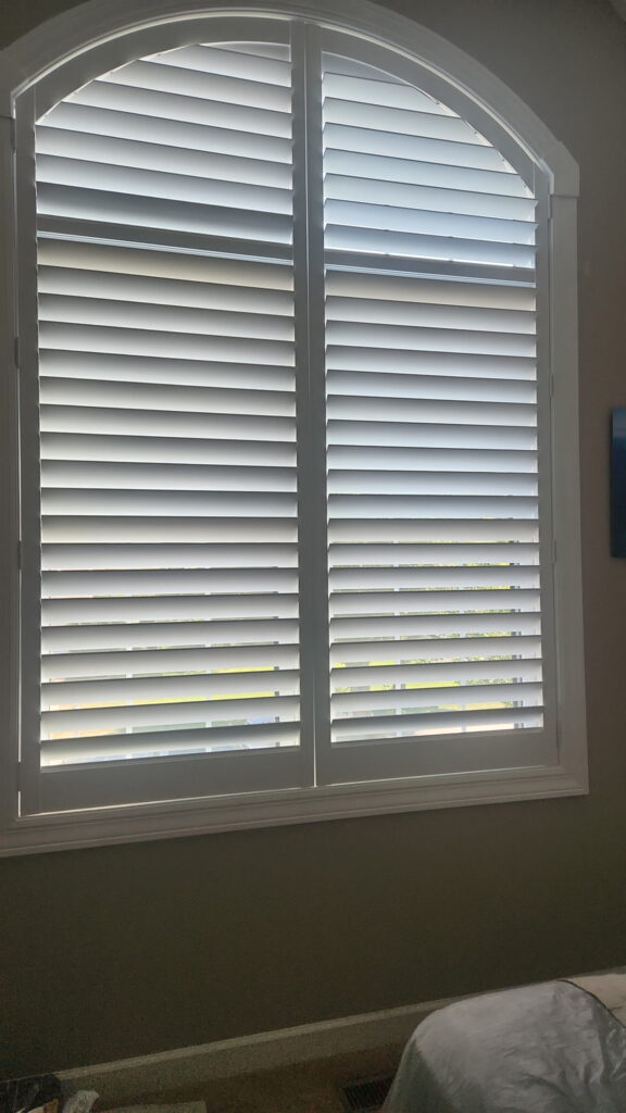 Custom built Hunter Douglas Arched Plantation Shutters sitting perfectly in an arched window