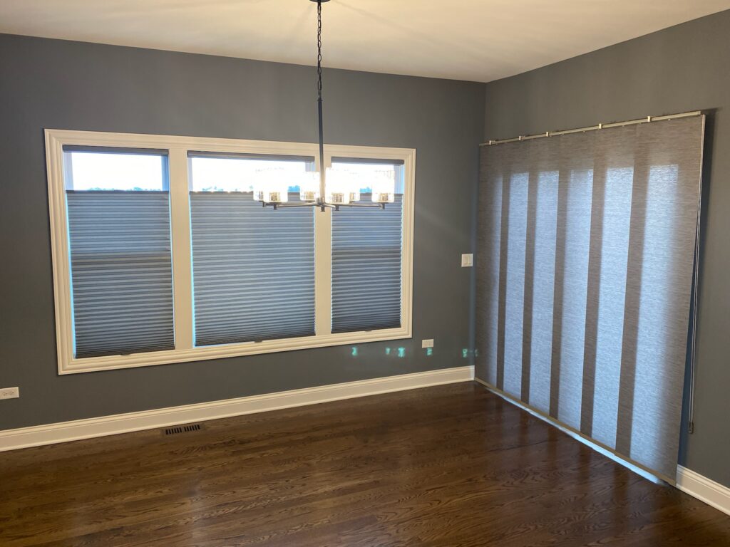 Skyline Panel-Track blind and duette cellular shade in an empty entryway.