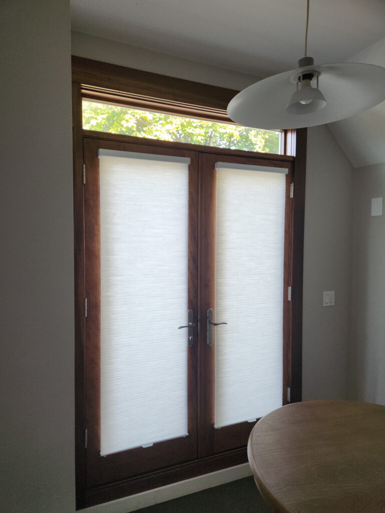 Hunter Douglas Duette Honeycomb shades hanging over French Door windows.