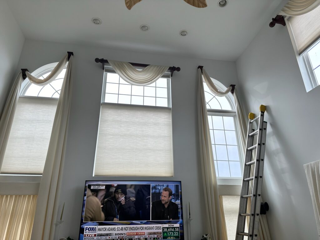 hunter Douglas duette cellular shades in a high ceiling family room with professional drapery