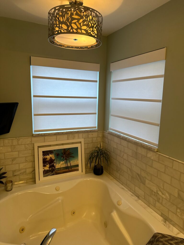 Hunter Douglas Alustra Architectural Roller Shades in two bathtub windows.