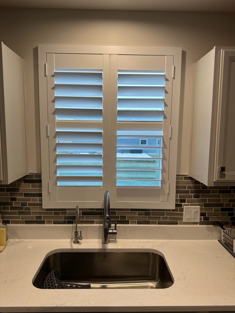 Mini plantation shutters over a small kitchen window.