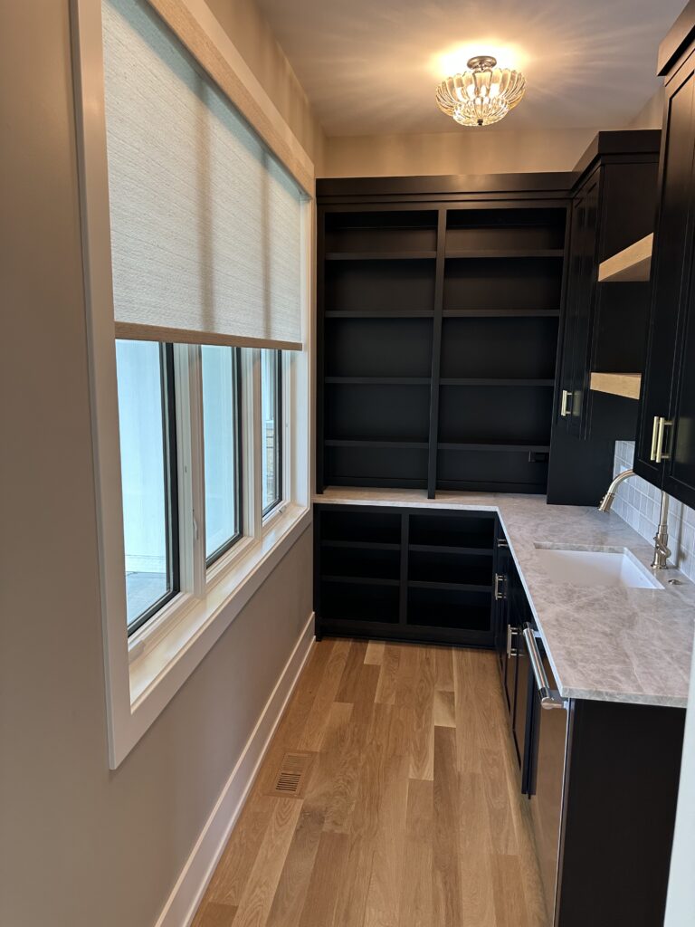 Gray Hunter Douglas Roller Shade hanging in a large pantry room window.