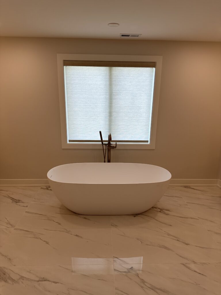 Hunter Douglas Roller Shade with a textured fabric in a bathroom with an extra large bath tub and granite floors