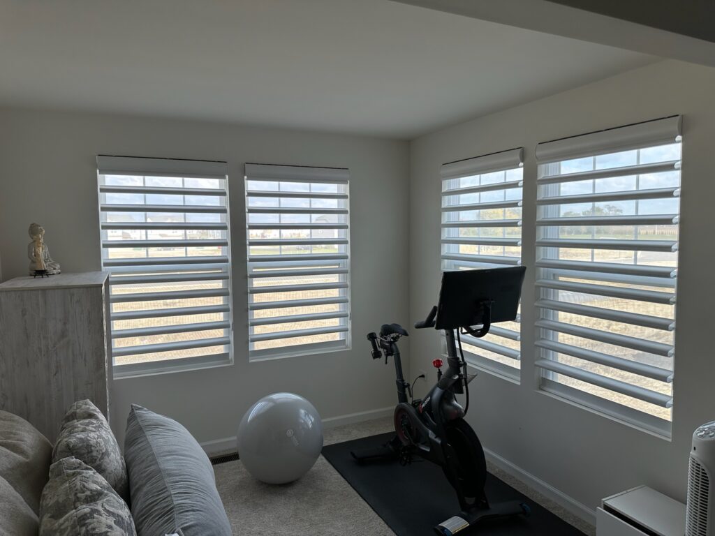 hunter Douglas pirouettes hanging in the windows on an in home gym