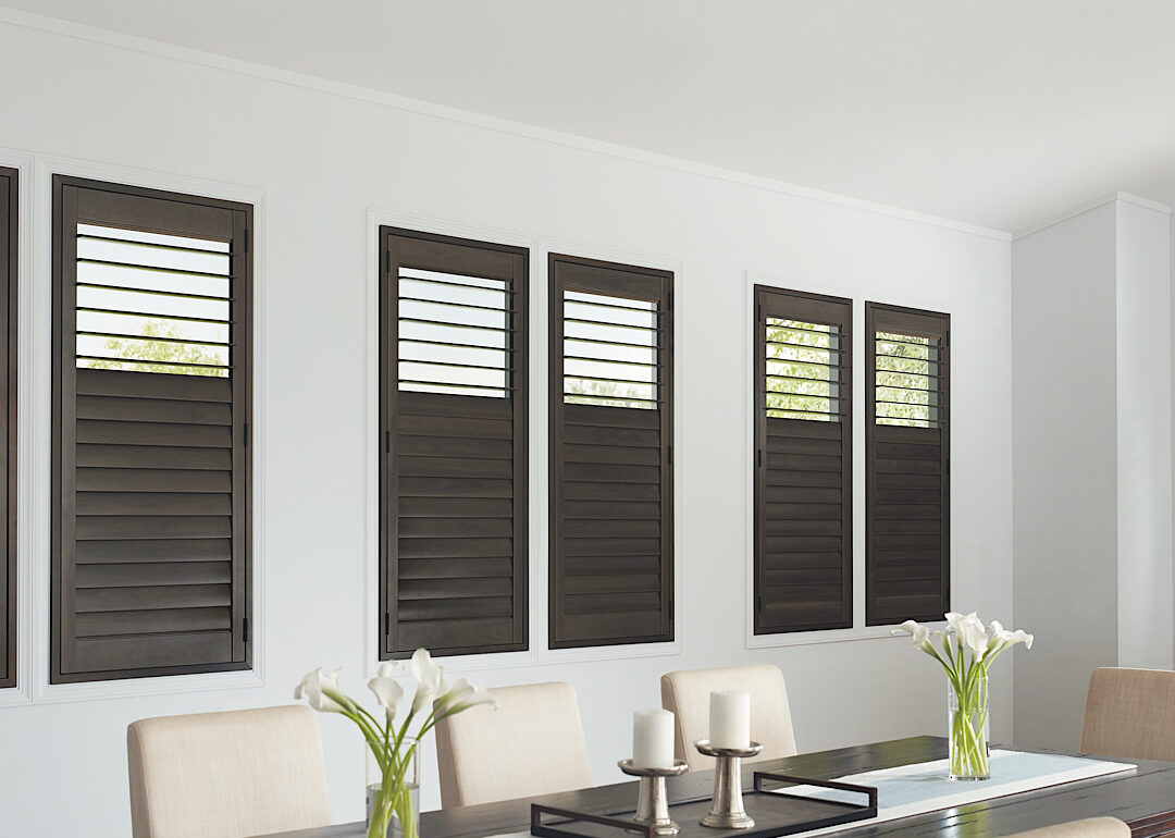 Hunter Douglas Heritance hardwood shutters in a dark, warm, gray stain in a modern room