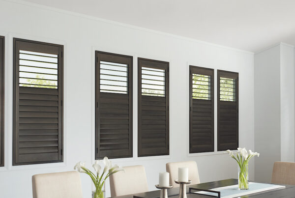 Hunter Douglas Heritance hardwood shutters in a dark, warm, gray stain in a modern room