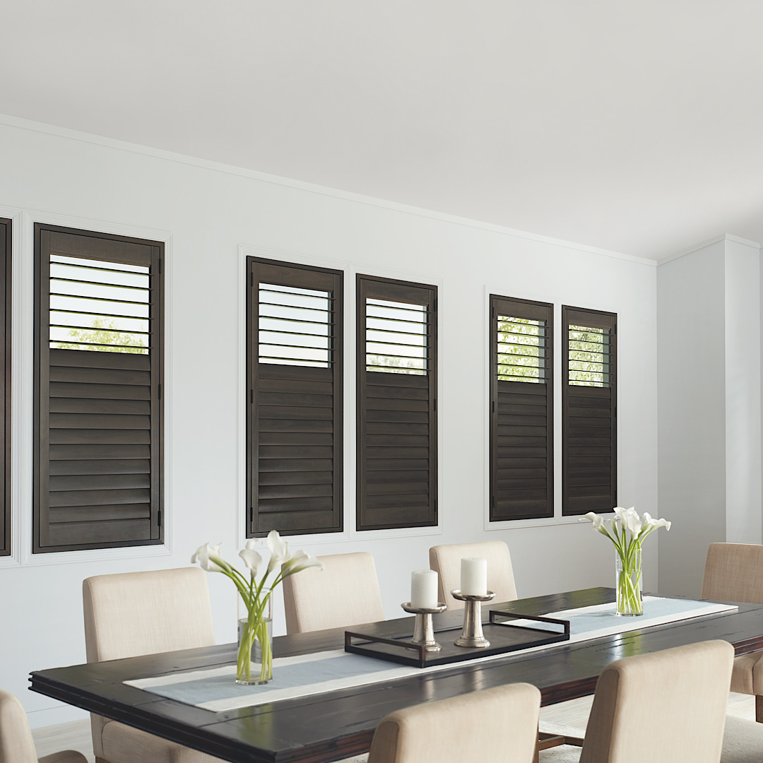 Hunter Douglas Heritance hardwood shutters in a dark, warm, gray stain in a modern room
